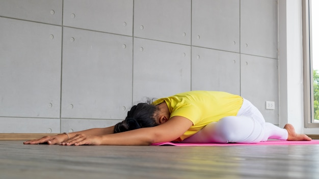 Junge Frau, die Sportbekleidung trägt, die Yoga praktiziert