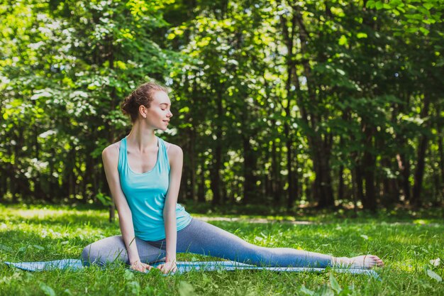 Junge Frau, die Streckübungen im Park tut