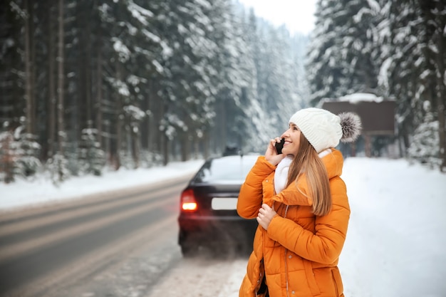 Foto junge frau, die telefonisch nahe straße im winterresort spricht