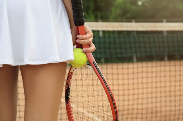 Junge Frau, die Tennis auf Platznahaufnahme spielt