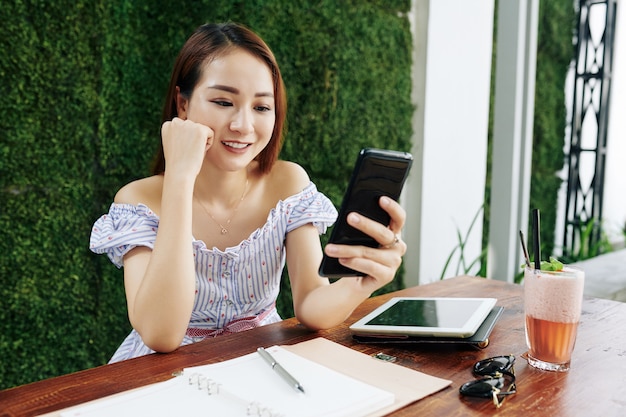 Junge Frau, die Textnachrichten liest