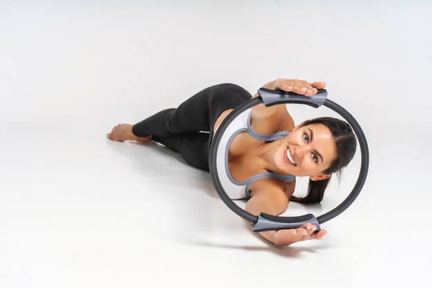 Junge Frau, die Übung mit Pilates-Kreis tut