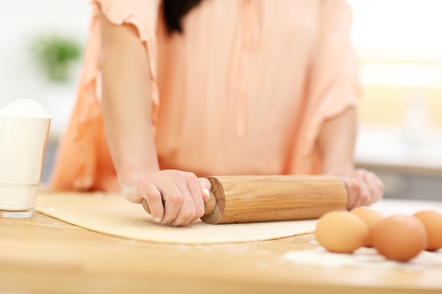 junge Frau, die versucht, etwas in der Küche zu kochen