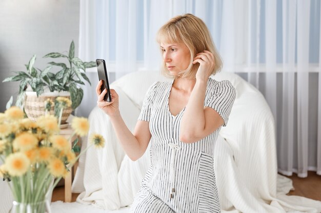 Junge Frau, die vom Home-Office aus arbeitet. Freiberufler mit Laptop, Telefon und Internet.