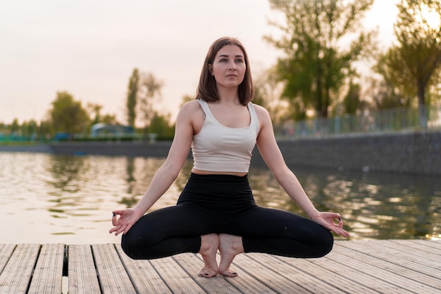 Foto junge frau, die yoga am see tut