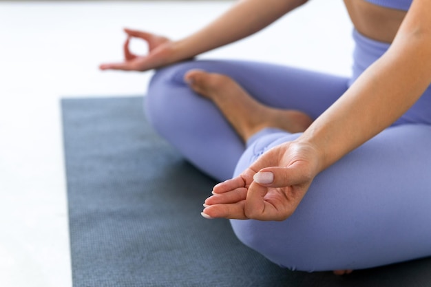 Junge Frau, die Yoga auf weißem Hintergrund praktiziert, gesunder Lebensstil und Wohlfühlkonzept