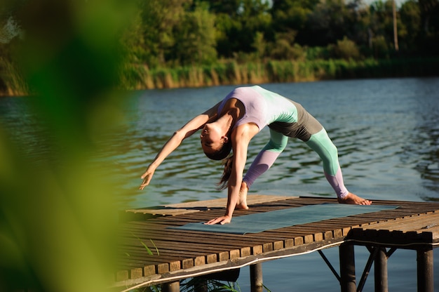 Junge Frau, die Yoga im Morgenpark tut.