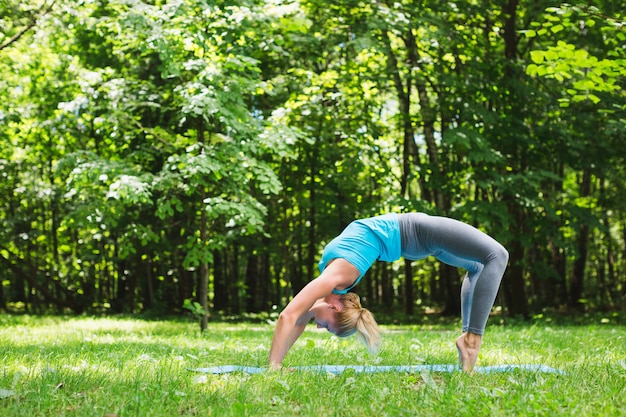 Junge Frau, die Yoga im Park tut