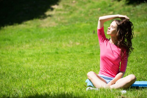 Junge Frau, die Yoga im Park tut