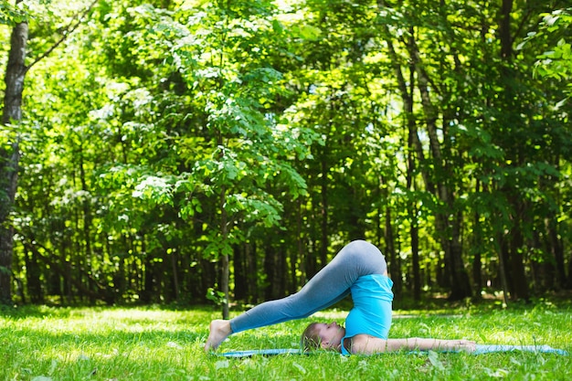 Junge Frau, die Yoga im Park tut