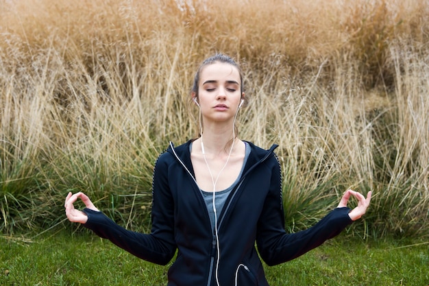 Junge Frau, die Yoga im Park tut