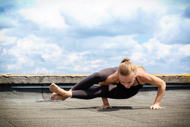 Junge Frau, die Yoga macht, ashtavakrasana