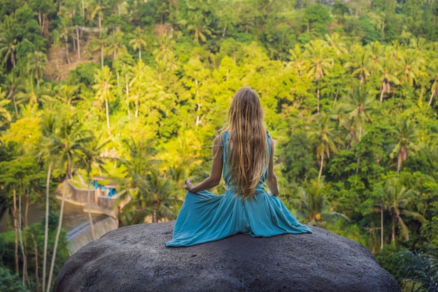 Foto junge frau, die yoga oder pilates bei sonnenuntergang oder sonnenaufgang in wunderschöner berglage praktiziert