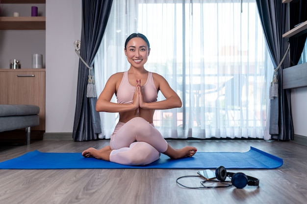Junge Frau, die Yoga zu Hause macht