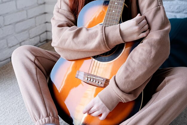 Junge Frau, die zu Hause Gitarre spielt