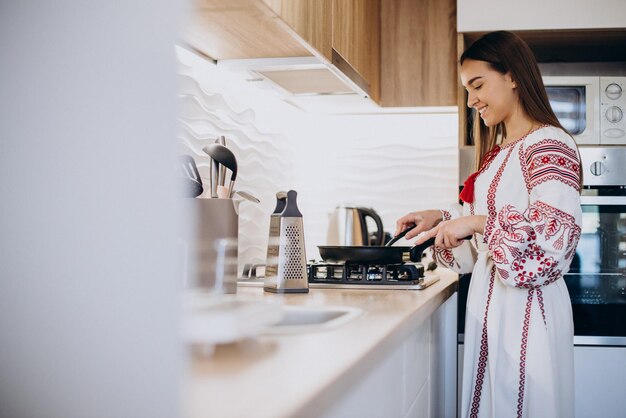 Junge Frau, die zu Hause in ihrer Küche Kaffee kocht