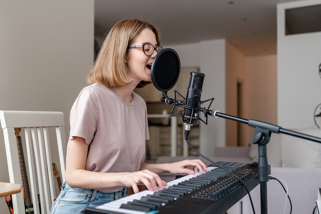 Junge Frau, die zu Hause spielt und singt