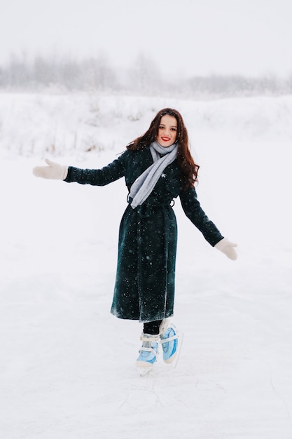 Junge Frau Eislaufen im Freien auf einem Teich an einem eiskalten Wintertag