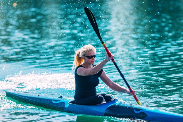 Junge Frau fährt Kajak auf dem See