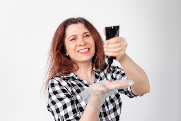 Junge Frau färbt sich zu Hause die Haare. Helles Haarfärbekonzept.