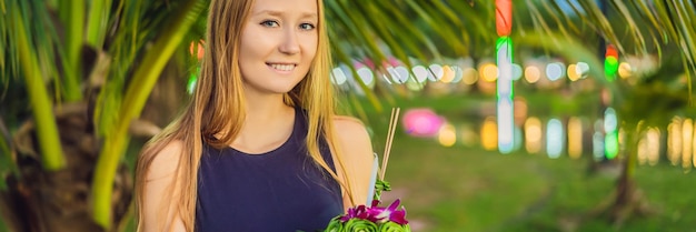 Junge frau feiert loy krathong läuft auf dem wasser loy krathong festival leute kaufen blumen und