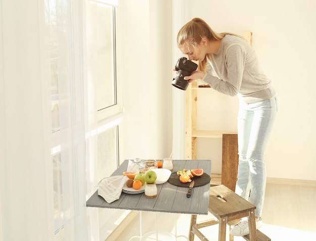 Junge Frau fotografiert Essen im Haus