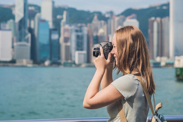 Junge Frau fotografiert Victoria Harbour in Hongkong, China.