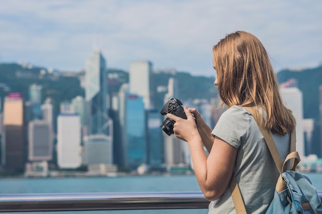 Junge Frau fotografiert Victoria Harbour in Hongkong, China.