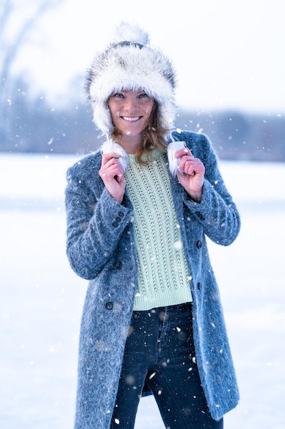 Junge Frau freut sich über den ersten Schnee im Winter