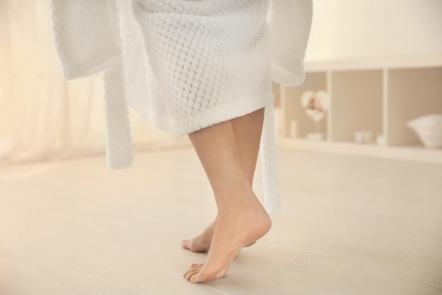 Junge Frau geht nach der Dusche auf den Boden