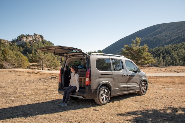 Junge Frau genießt die Landschaft in einem Wohnmobil