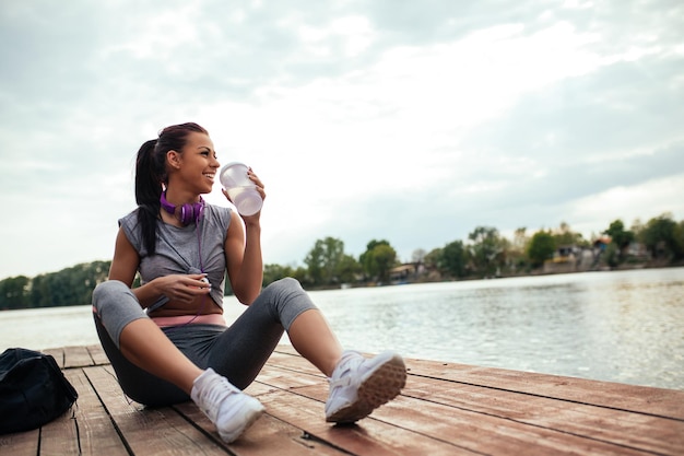 Junge Frau genießt eine Pause neben dem Fluss.