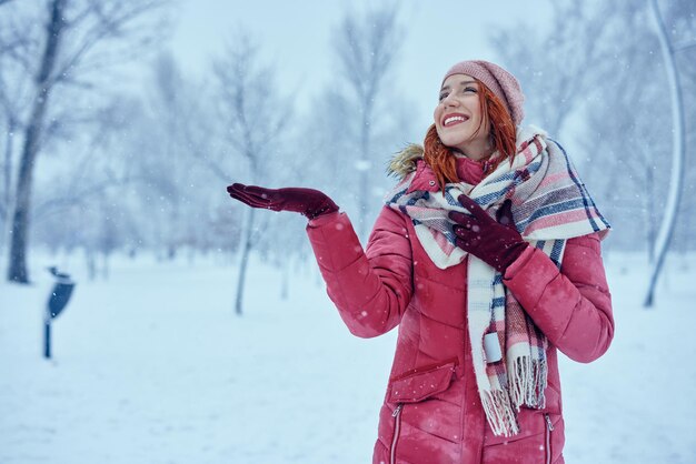 Junge Frau genießt es, draußen im Schnee zu sein