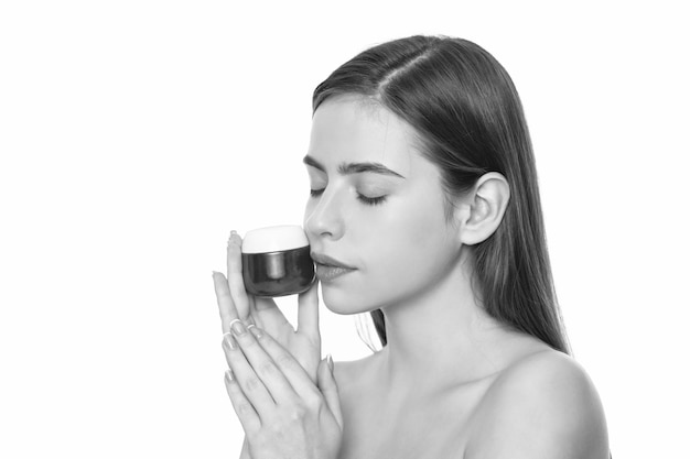 Junge Frau hält Cremetiegel für Gesichtshaut isoliert auf weißem Hintergrund mit Kopierraumanzeige
