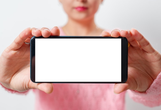 junge Frau hält das Smartphone horizontal mit einem weißen Bildschirm mit einem Platz