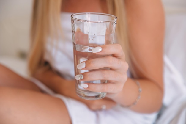 Foto junge frau hält ein trinkwasserglas in der hand