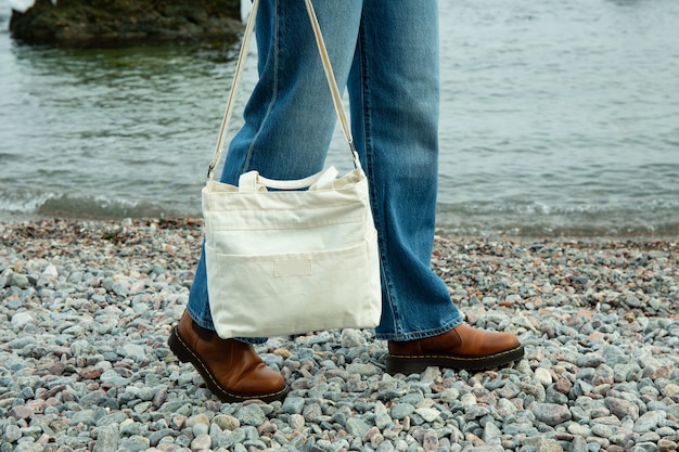 Junge Frau halten stilvolle Öko-Tasche am Kieselstrand