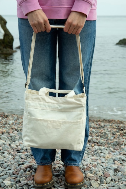 Junge Frau halten stilvolle Öko-Tasche am Strand