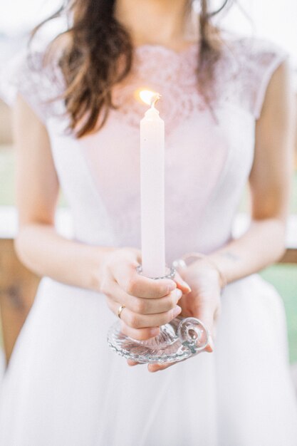 Junge Frau im Abendkleid, das Kerze hält