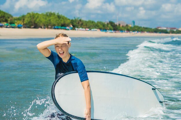 Junge Frau im Badeanzug mit Brandung für Anfänger bereit zum Surfen. Positive Gefühle