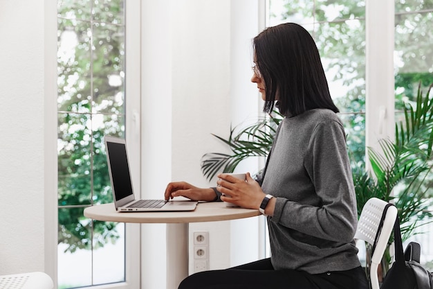 Junge Frau im Café mit Laptop