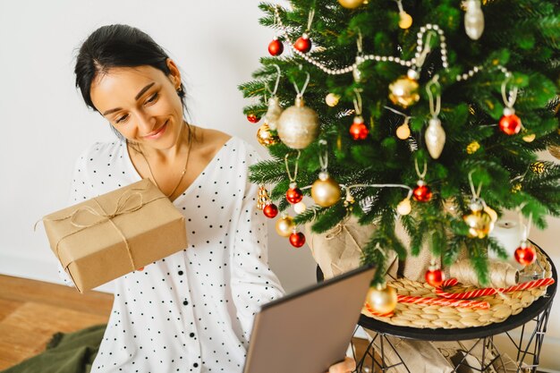 junge Frau im Chat online gratulieren Familie oder Freunde mit digitalen Tablet. Video-Chat mit Eltern und Großeltern am Weihnachtsabend Weihnachtsvideo-Gruß