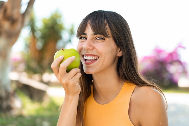 Junge Frau im Freien mit einem Apfel