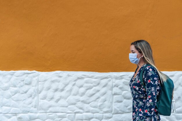 Junge Frau im Freien mit medizinischer Maske. Pandemiefrau mit Schutzmaske auf der Straße. Gesundheits- und Sicherheitskonzept