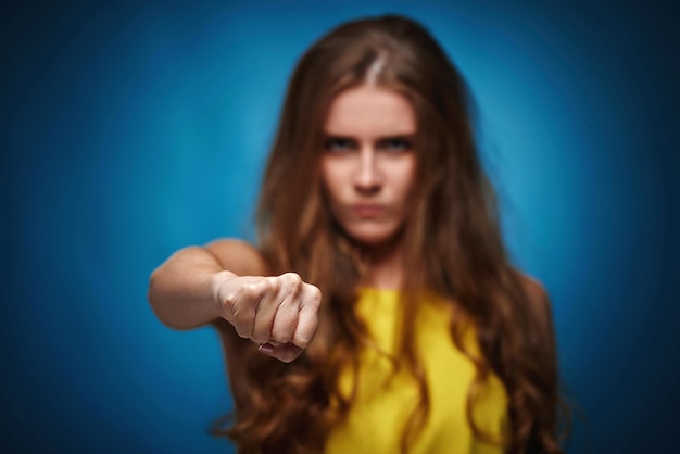 Junge Frau im gelben T-Shirt auf blauem Hintergrund