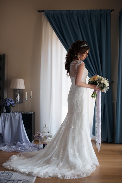 Junge frau im hochzeitskleid drinnen