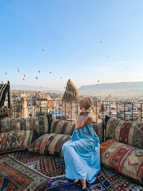 Junge Frau im Kleid auf dem Dach mit herrlichem Blick auf Kappadokien in der Türkei