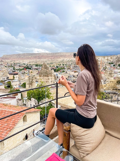 Junge Frau im Kleid auf dem Dach mit herrlichem Blick auf Kappadokien in der Türkei