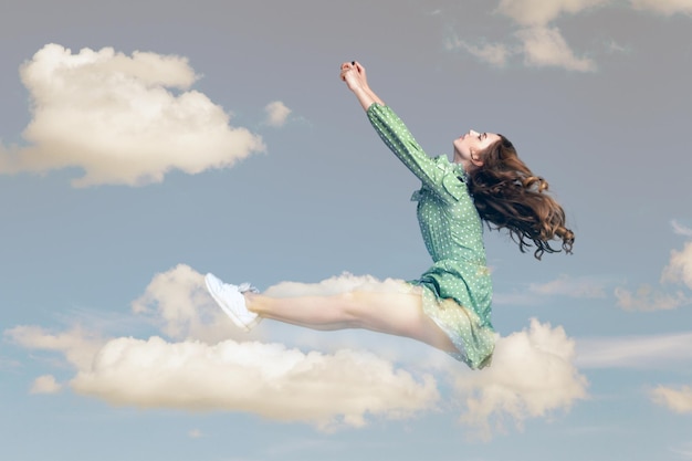 Junge Frau im Kleid, das in den Himmel fliegt