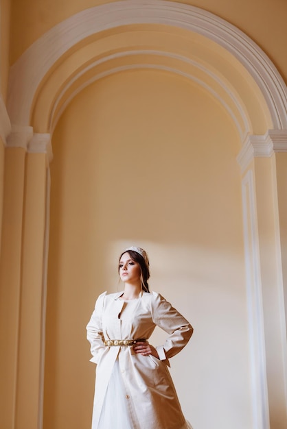 Junge Frau im Kleid steht an der Wand